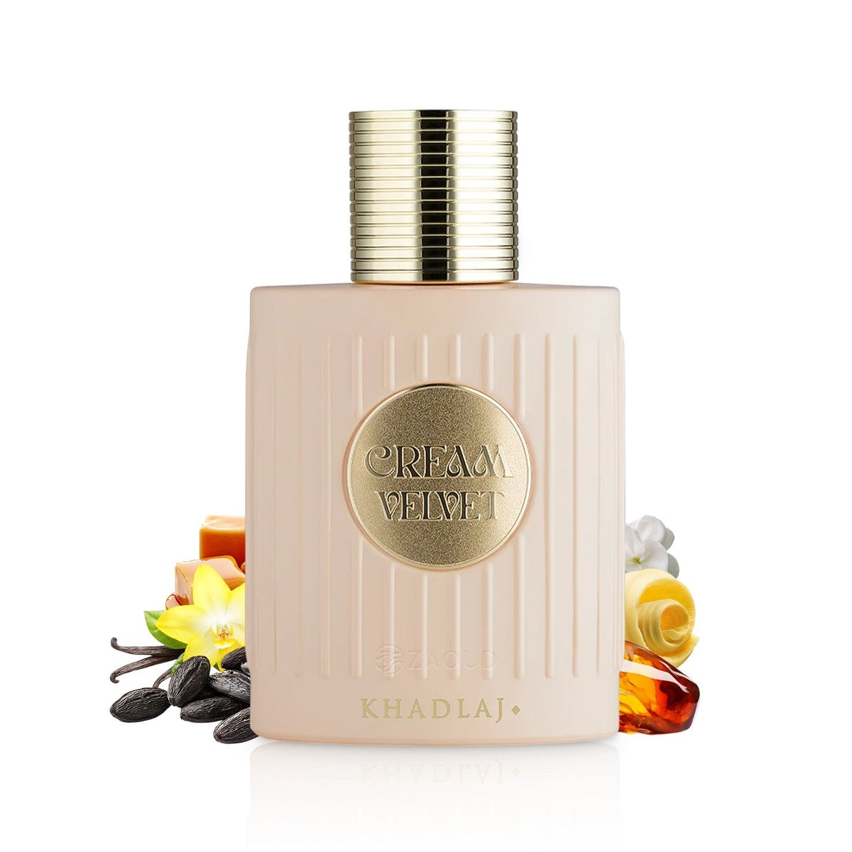 A bottle of Khadlaj Cream Velvet perfume with a pale pink ribbed body and a gold cap, styled with scent ingredients like vanilla, amber, and citrus on a white background.